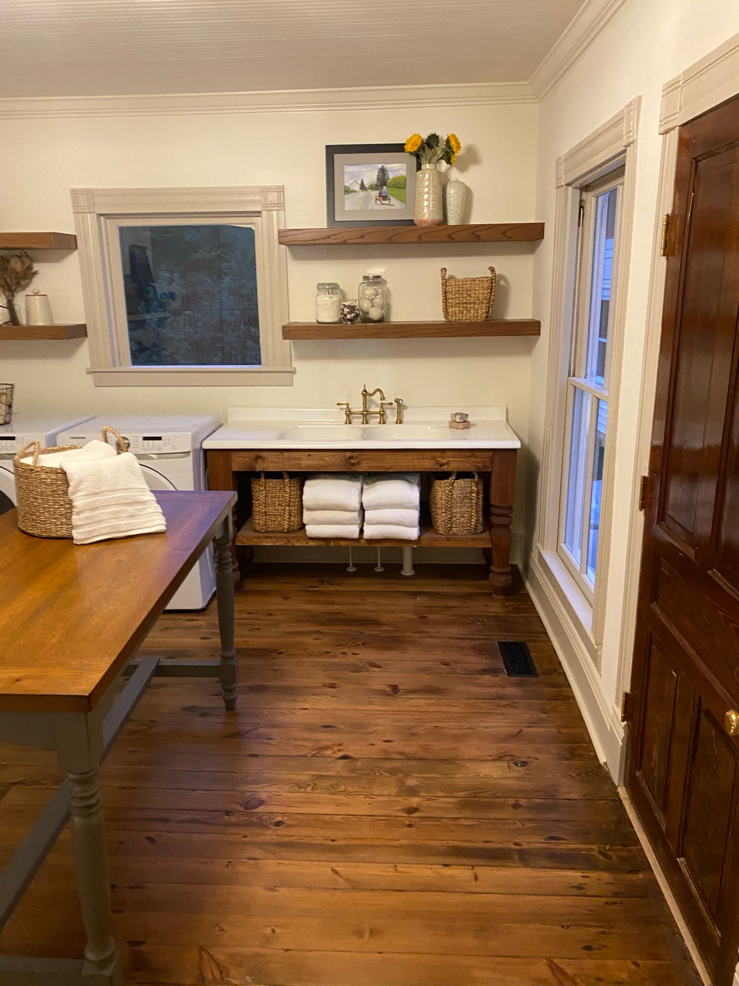 Laundry room vanity and open shelving in stained wood, set against the restored heart pine floors