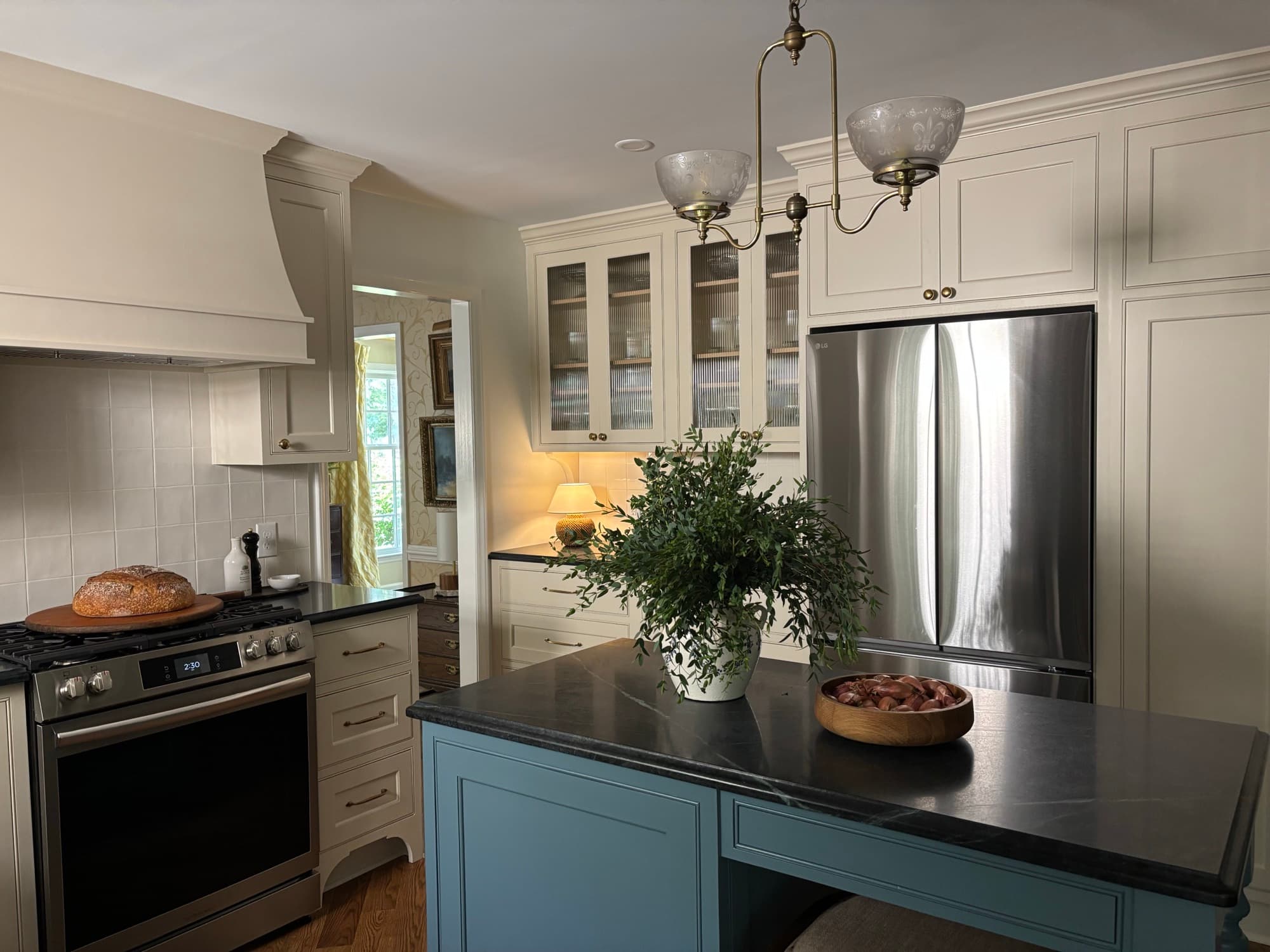 Custom kitchen cabinetry with crown molding and a marble-topped island