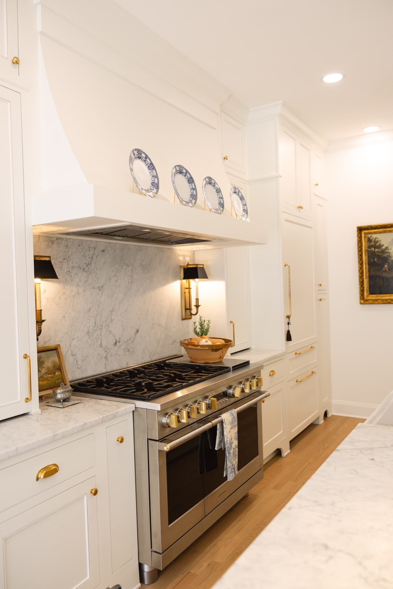 Raleigh kitchen with inset cabinetry, a plate shelf over the range, marble backsplash, and brass hardware, built by Jim Cooper Cabinetry